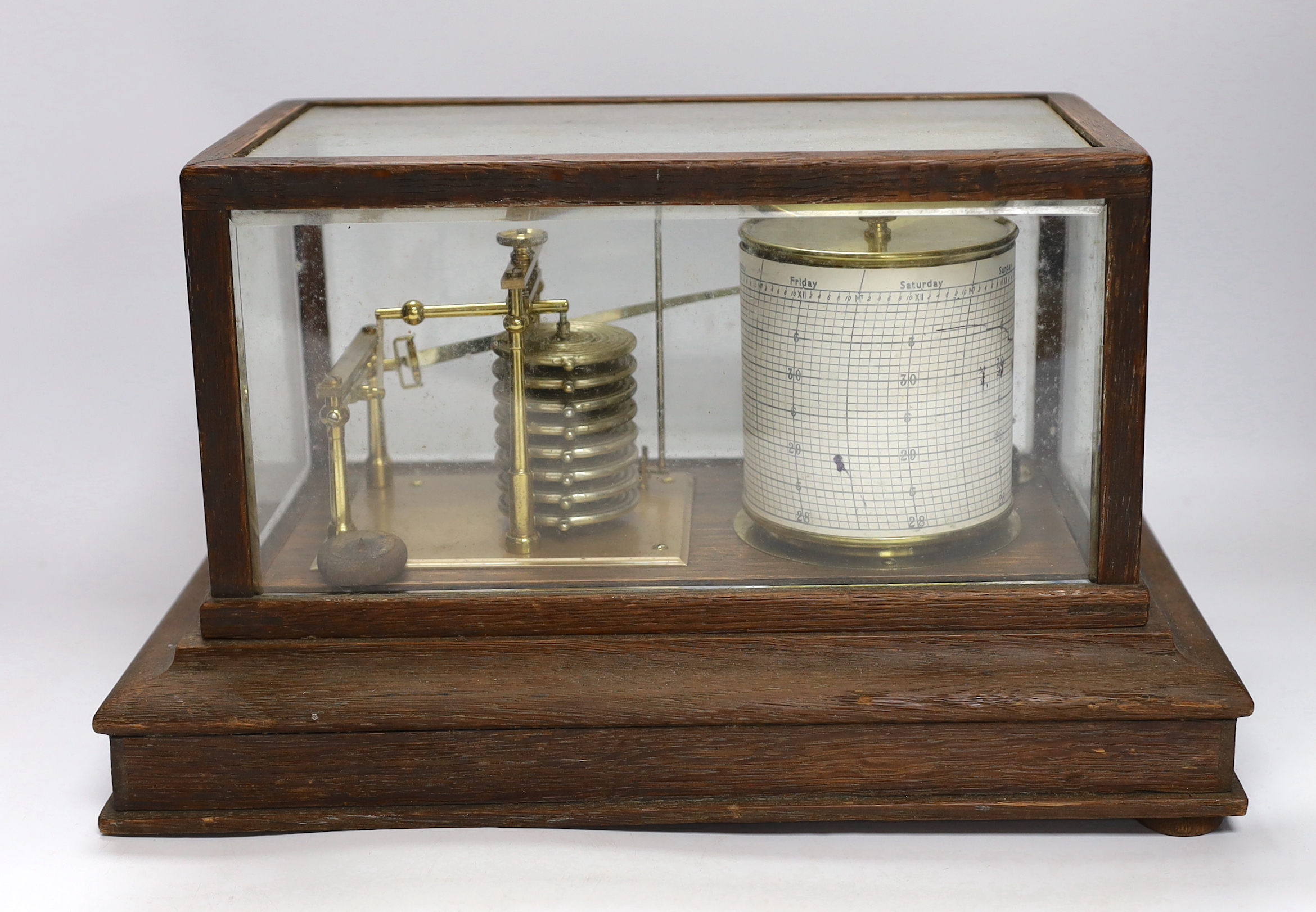 A barograph by Dollond in an oak case with bevelled glass panels and incorporating an ink bottle and a drawer with spare graph papers, 36.5cm x 21.5cm